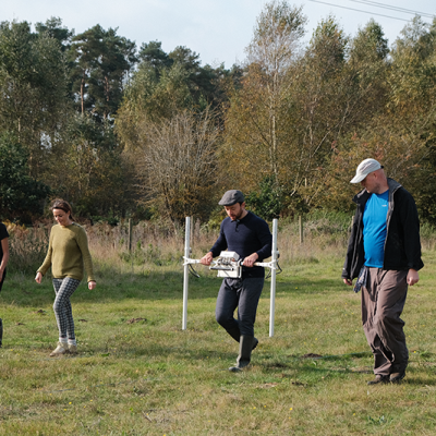 four people walking with magnetometer