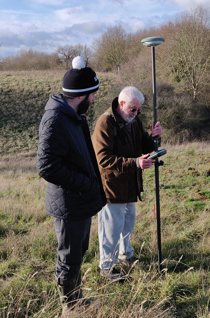 two people standing in field with GPS device